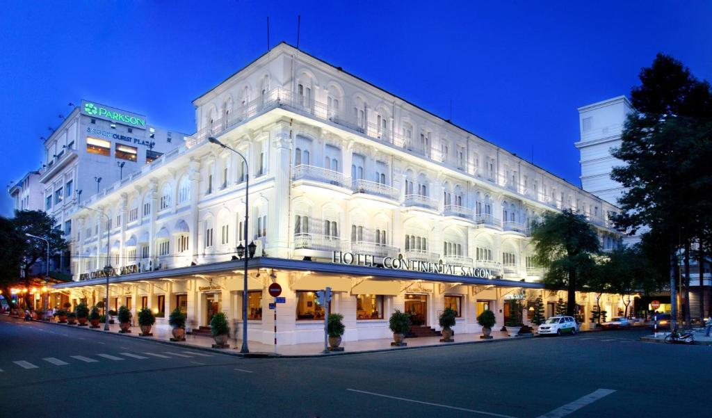 ein großes weißes Gebäude in der Nacht auf einer Stadtstraße in der Unterkunft Hotel Continental Saigon in Ho-Chi-Minh-Stadt