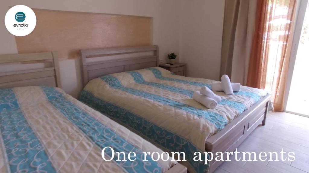 a bedroom with two beds with towels on them at Evridiki Hotel in Fourka