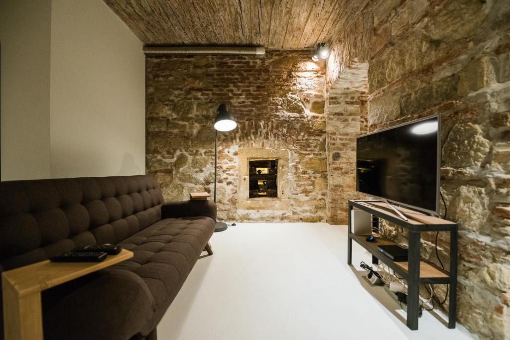 a living room with a couch and a stone wall at Old Central Apartment in Cluj-Napoca