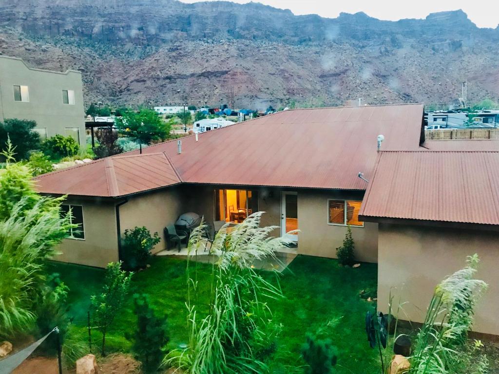 una casa con techo rojo con una montaña al fondo en Oleander Place, en Moab