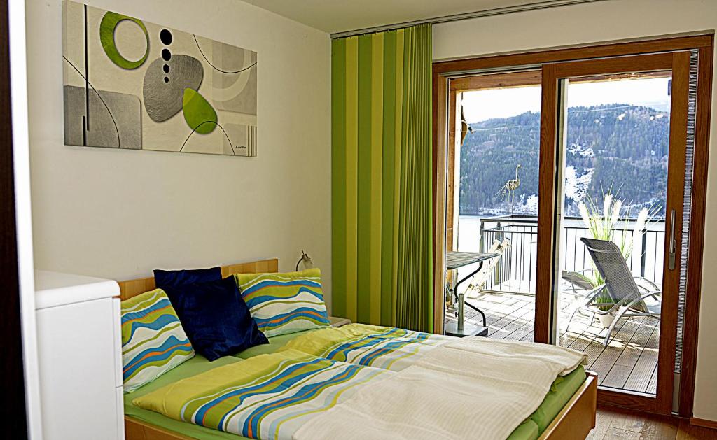 a bedroom with a bed and a balcony at Ferienwohnungen Klinar in Millstatt