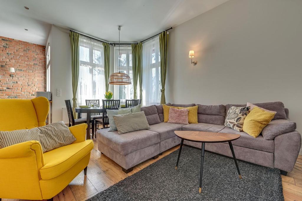 ein Wohnzimmer mit einem Sofa, Stühlen und einem Tisch in der Unterkunft Lion Apartments - Scandi Love II in Sopot