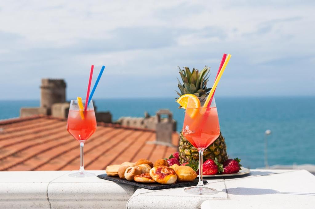 - deux cocktails et une assiette de nourriture sur une table dans l'établissement Casa Vacanze B&B Uccialì, à Le Castella