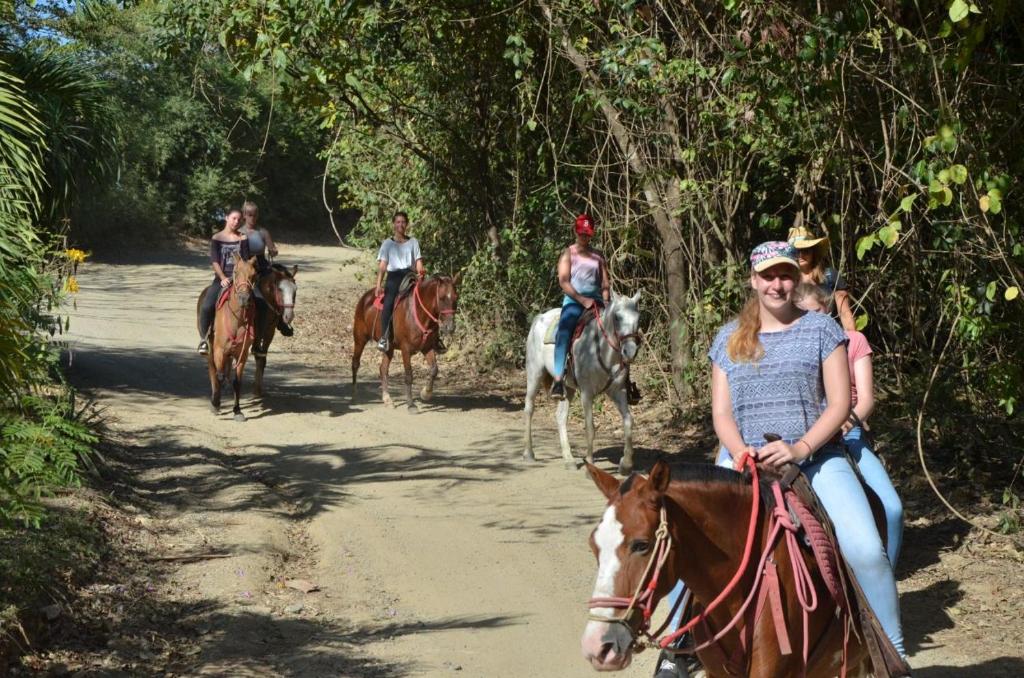 a group of people riding horses on a dirt road at Chicama : Burnt Toast Surfcamp in Nosara