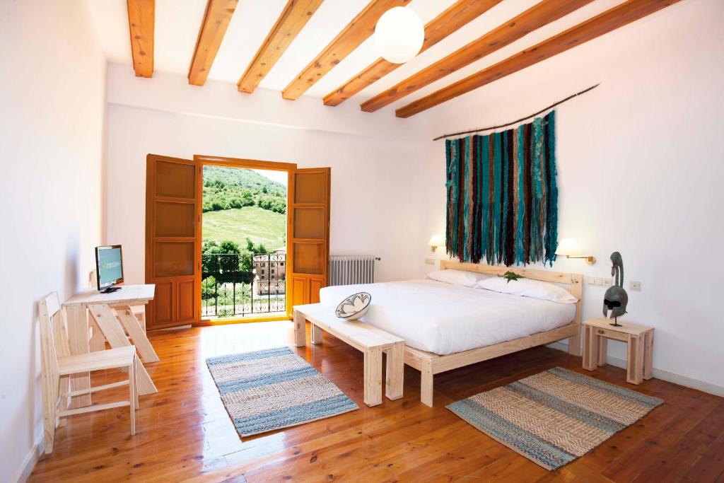 1 dormitorio con cama, mesa y ventana en Posada Hoyos de Iregua, en Villoslada de Cameros