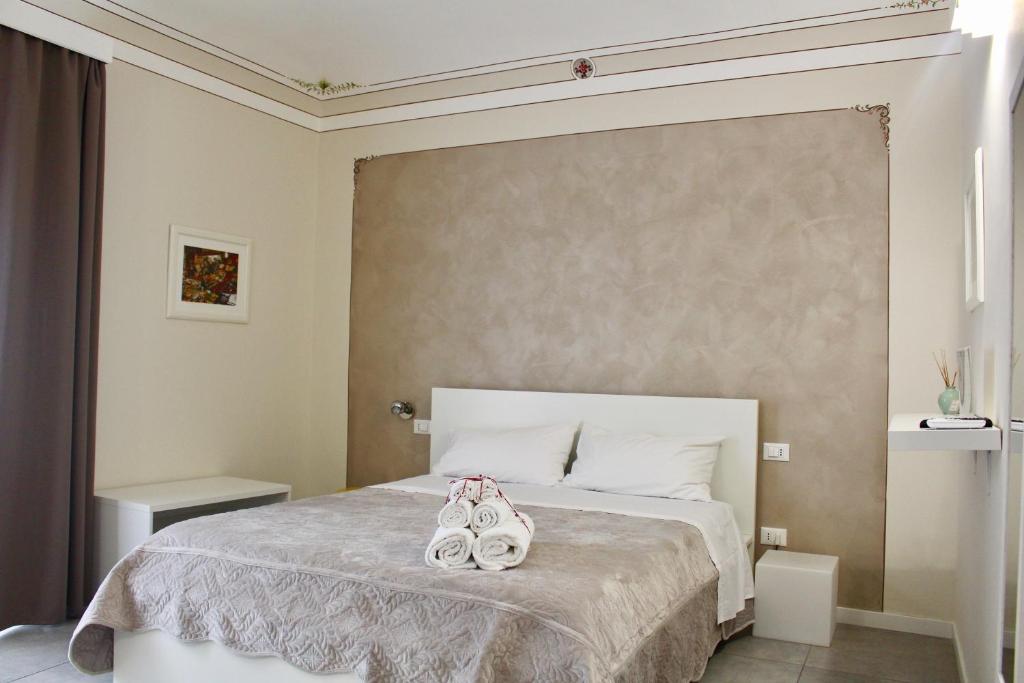 a bedroom with a bed with two pairs of shoes on it at Triscele Glamour Rooms in Palermo