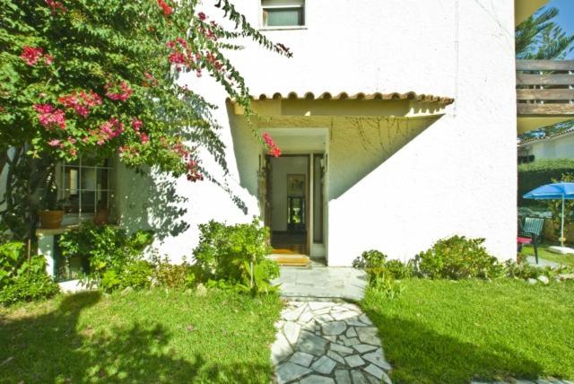 une maison blanche avec un chemin menant à la porte d'entrée dans l'établissement Traditional Villa In S Pedro , ESTORIL, à Alapraia