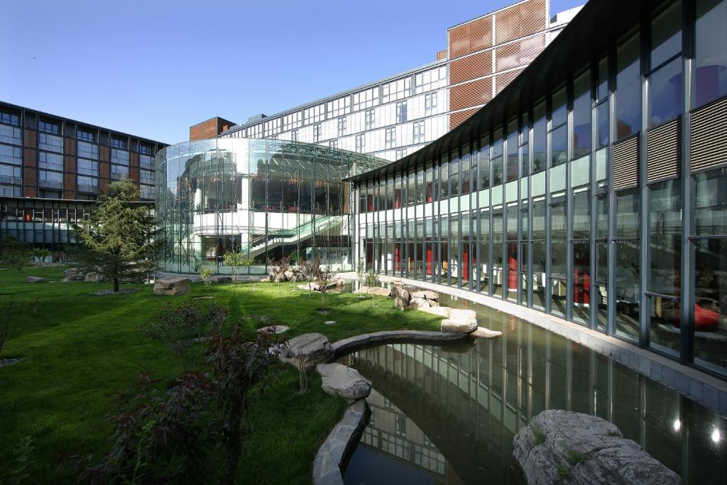 a large building with a pond in front of a building at The Lakeview Hotel in Beijing