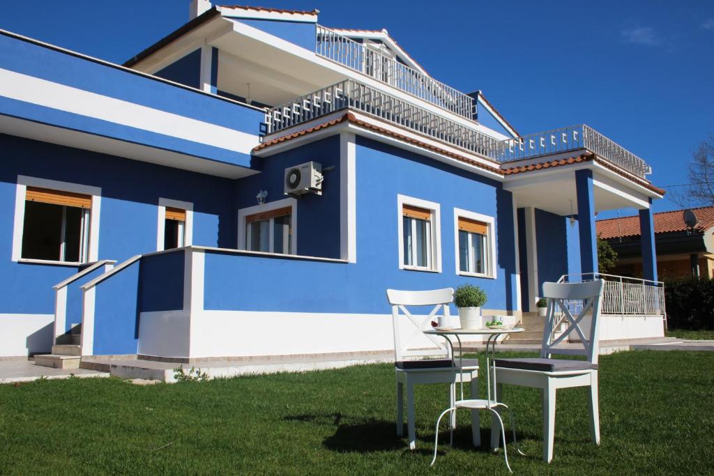 una casa azul con una mesa y sillas en el patio en Villa Le Garden en Nettuno