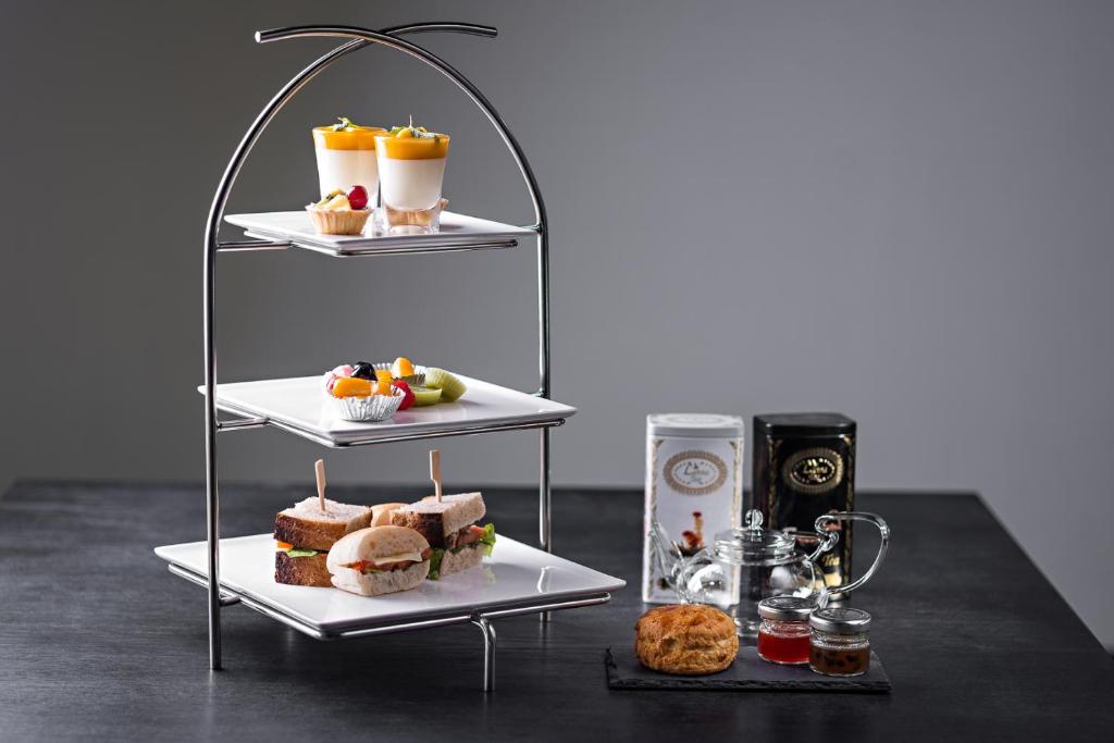 A styled afternoon-tea or breakfast stand with pastries, sandwiches and preserves.