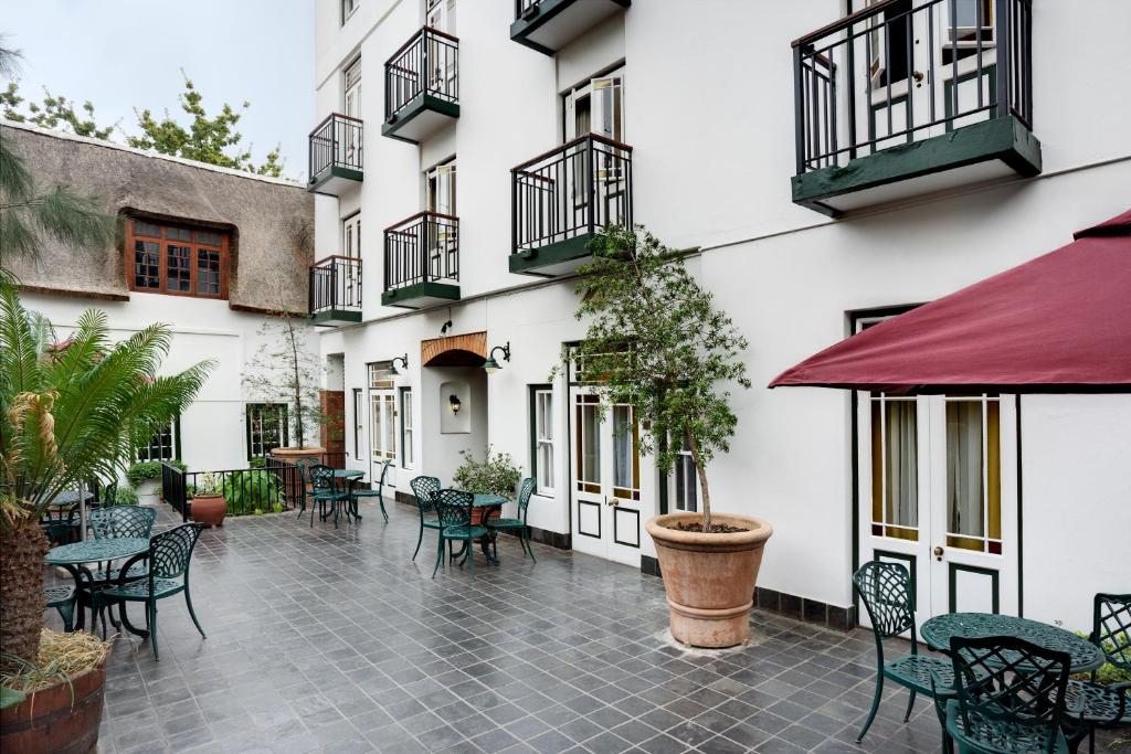 a courtyard with tables and chairs in a building at The Stellenbosch Hotel in Stellenbosch