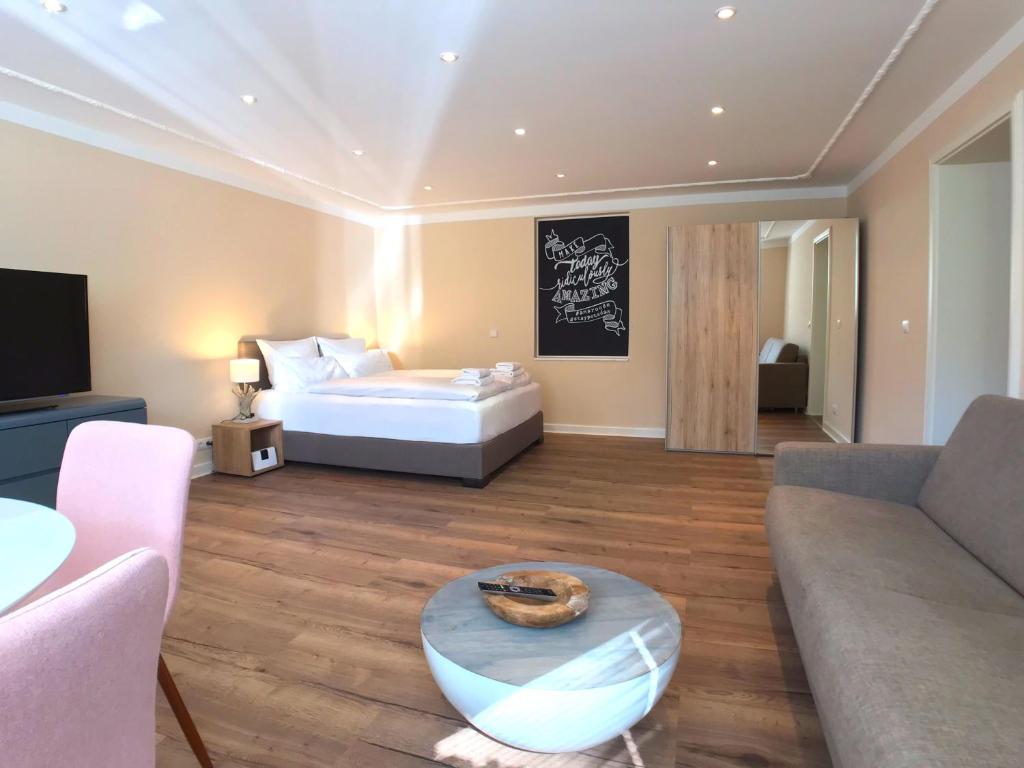 ein Schlafzimmer mit einem Bett, einem Sofa und einem Tisch in der Unterkunft Amaroo - Apartments Potsdam “Alexandrowka” in Potsdam