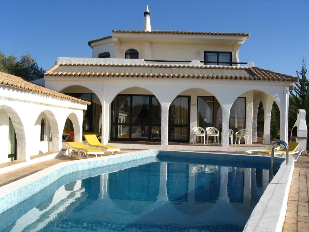 una casa con piscina frente a una casa en Quinta das Flores, en Albufeira