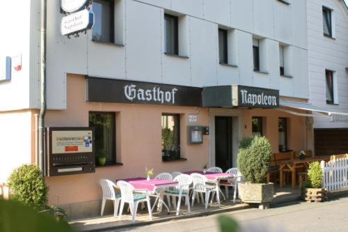 un restaurant avec des tables et des chaises en face d'un bâtiment dans l'établissement Gasthof Napoleon, à Selbitz