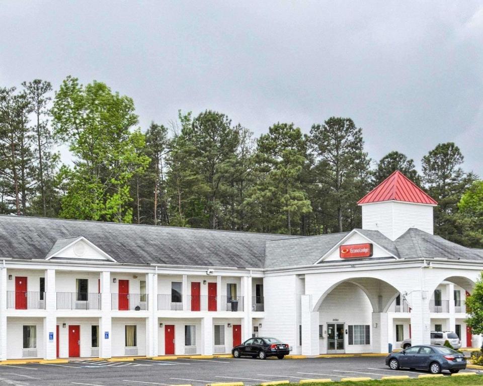 a large white building with a red roof at Econo Lodge in Ruther Glen