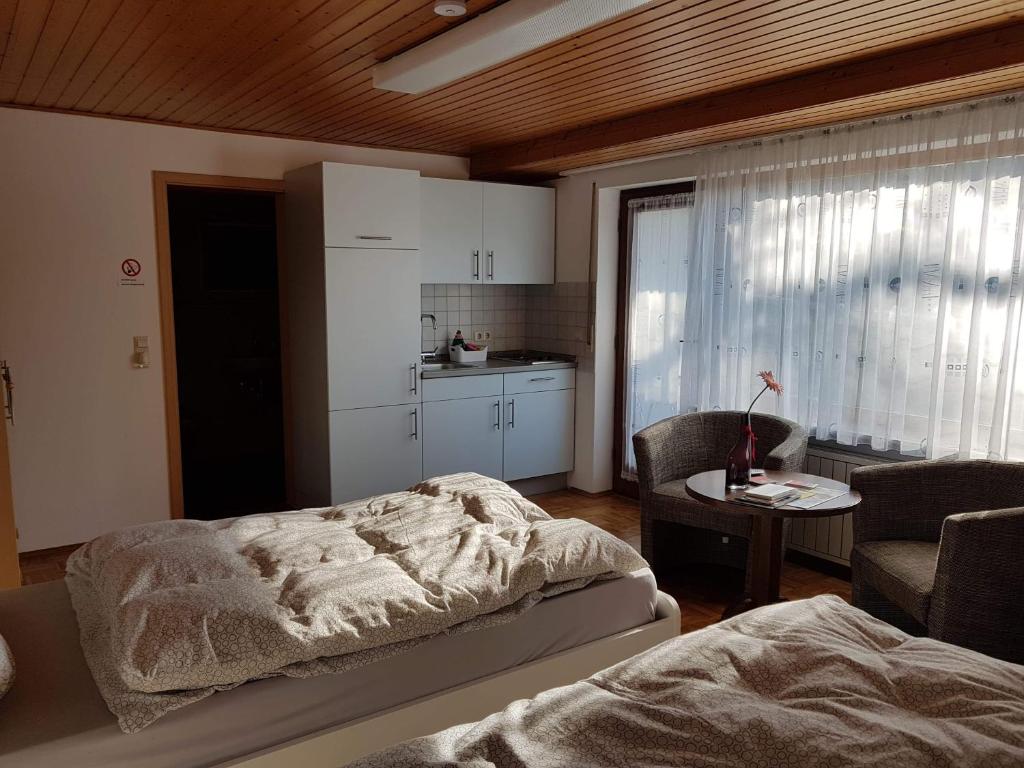 a bedroom with a bed and a table and a kitchen at G.O.D. Ferienwohnung in Bad Mergentheim