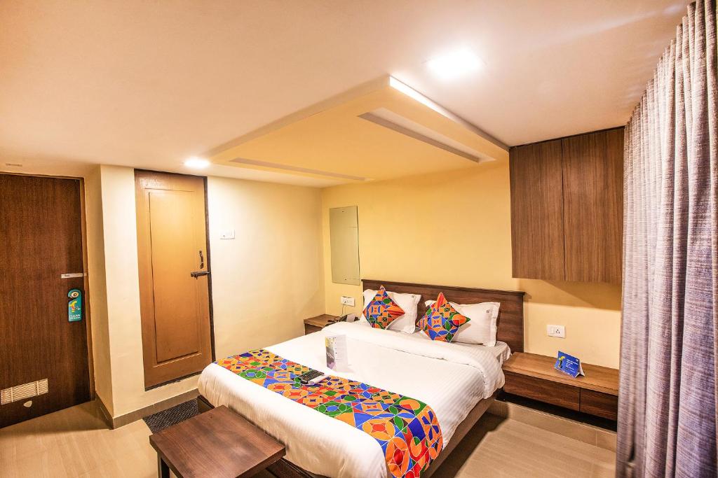 um quarto de hotel com uma cama e uma porta de madeira em FabExpress Silver Lake em Mumbai