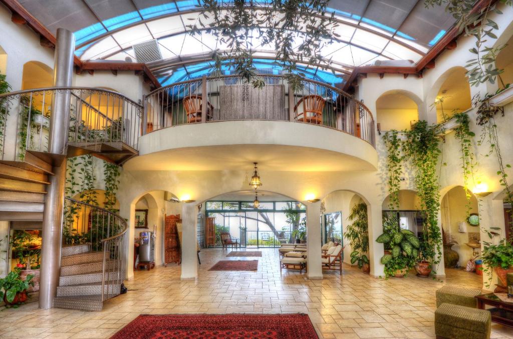 a large lobby with a glass ceiling and plants at Amirey Hagalil Boutique Hotel in Amirim