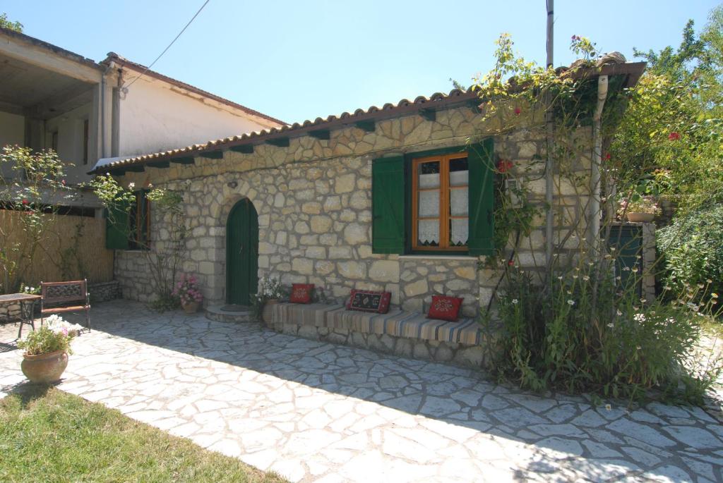 a stone house with a window and a patio at Villa Frias in Asprogerakata