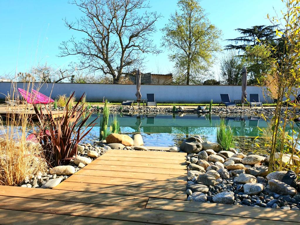 a pool with a wooden walkway in a yard at Les Granges de Jules in Lafitte-Vigordanne
