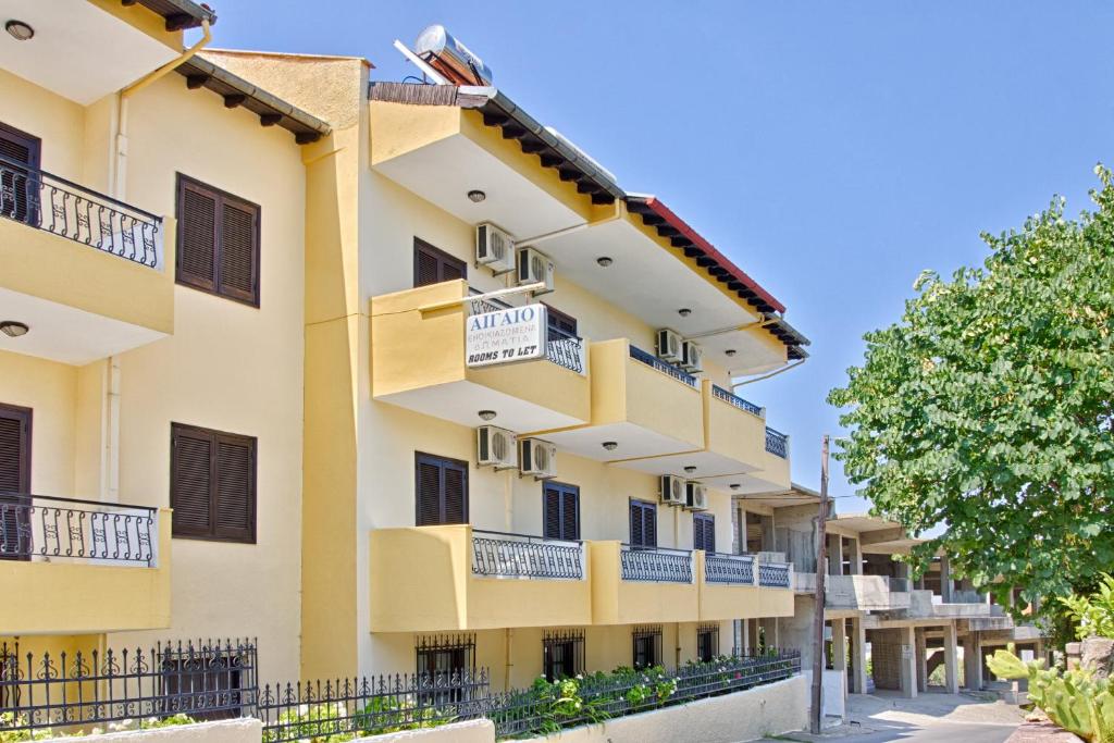 ein Apartmenthaus mit Balkon und einem Baum in der Unterkunft Aigaio in Kriopigi