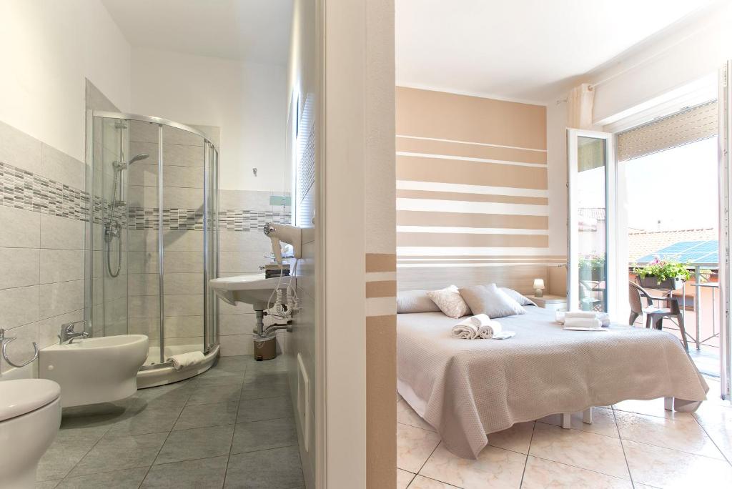 een slaapkamer met een bed en een badkamer met een bad bij Alguest in Alghero
