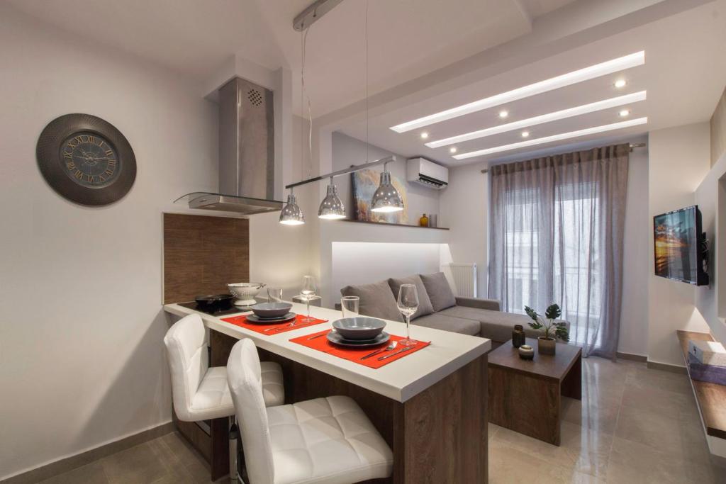 eine Küche und ein Wohnzimmer mit einem Tisch und Stühlen in der Unterkunft Deluxe Arch of Galerius in Thessaloniki