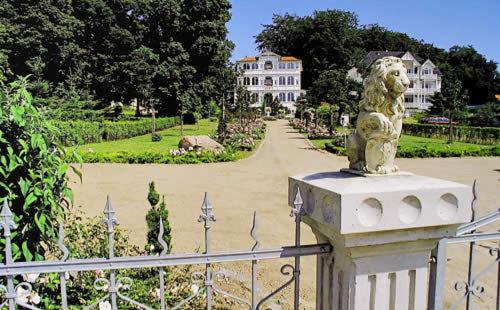 una estatua de un león sentado en la parte superior de una valla en Pension Villa Edelweiß, en Ostseebad Sellin