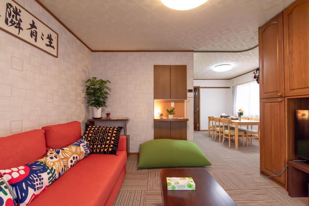 sala de estar con sofá rojo y mesa en Hong house en Tokio