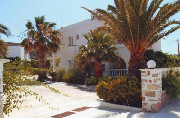 un edificio blanco con palmeras delante en Angela's, en Galissas