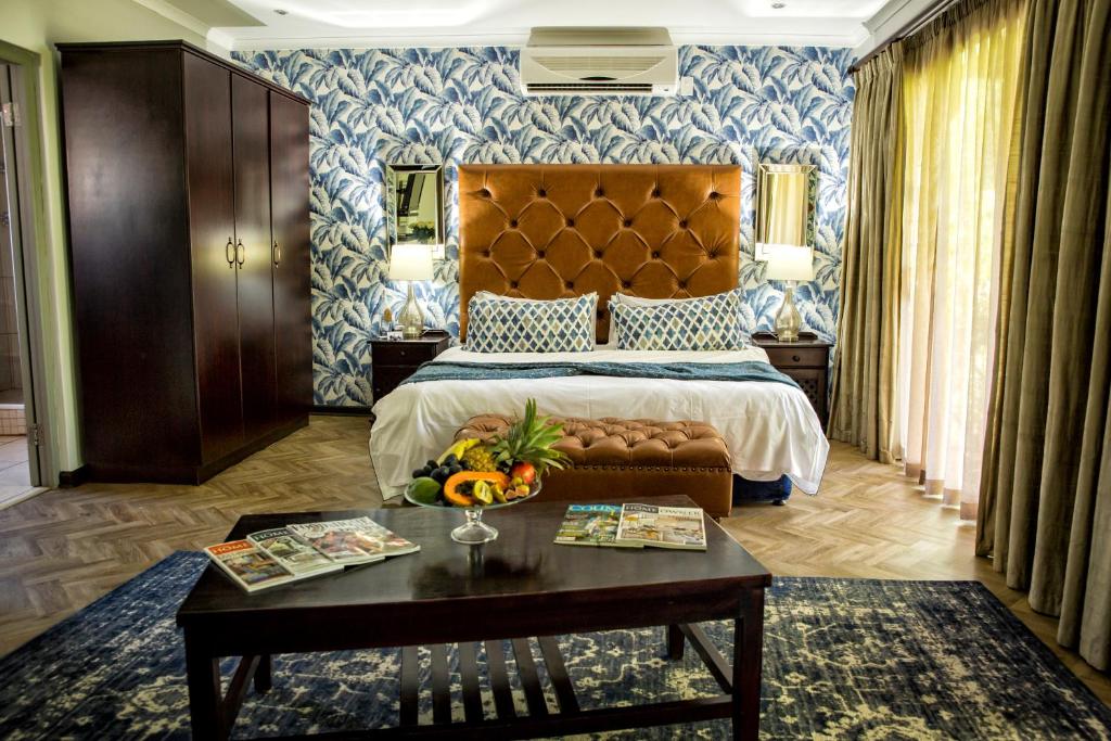 una habitación de hotel con una cama y una mesa con frutas en Browns Manor, en Upington