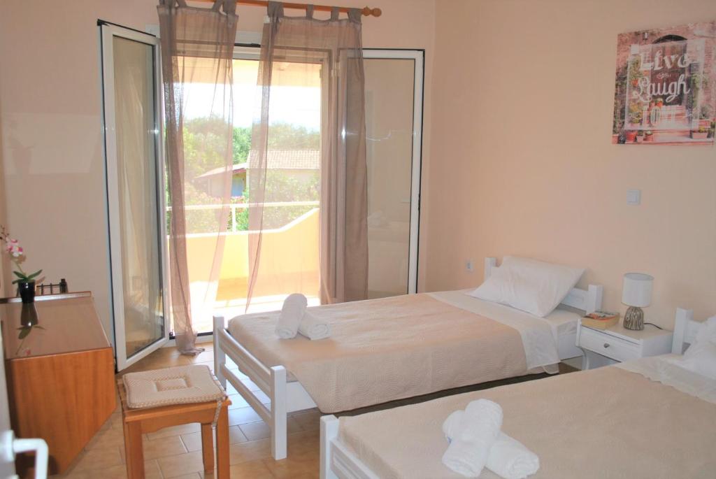 1 dormitorio con 2 camas y ventana grande en Lefkothea Apartments en Kassiopi