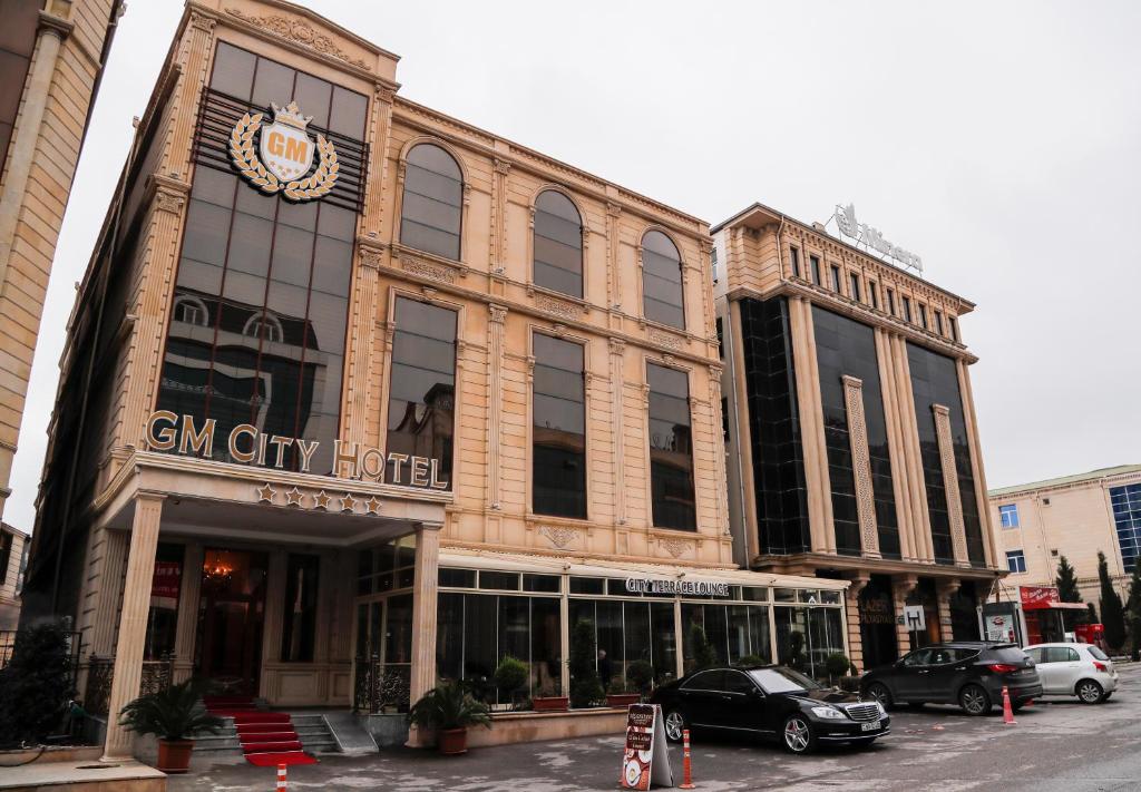um edifício numa rua com carros estacionados em frente em GM City Hotel em Baku