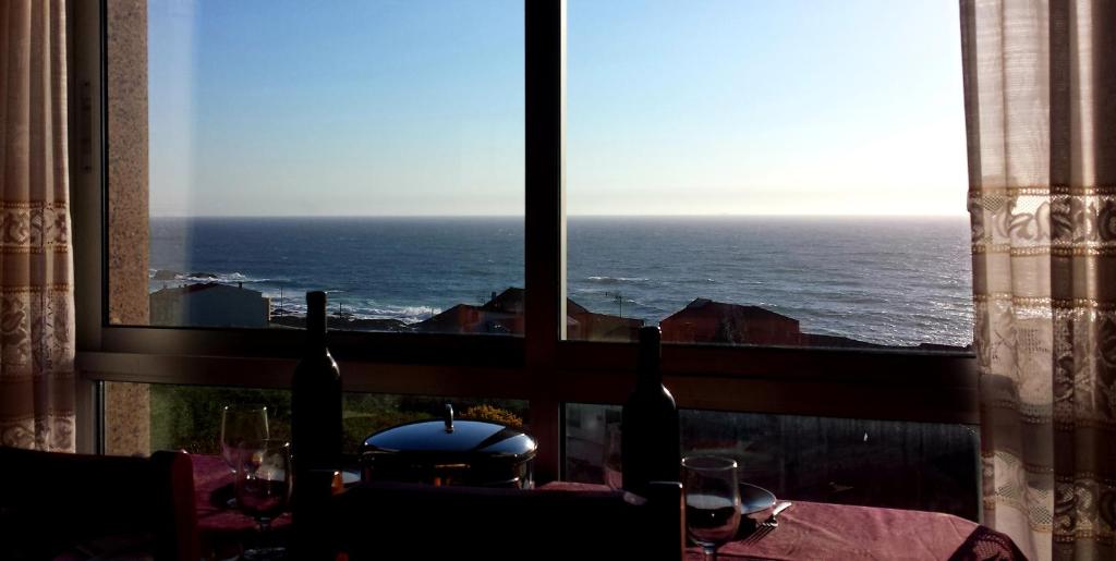 uma mesa com vista para o oceano a partir de uma janela em RINCON DO MAR 1 IZ em A Guarda