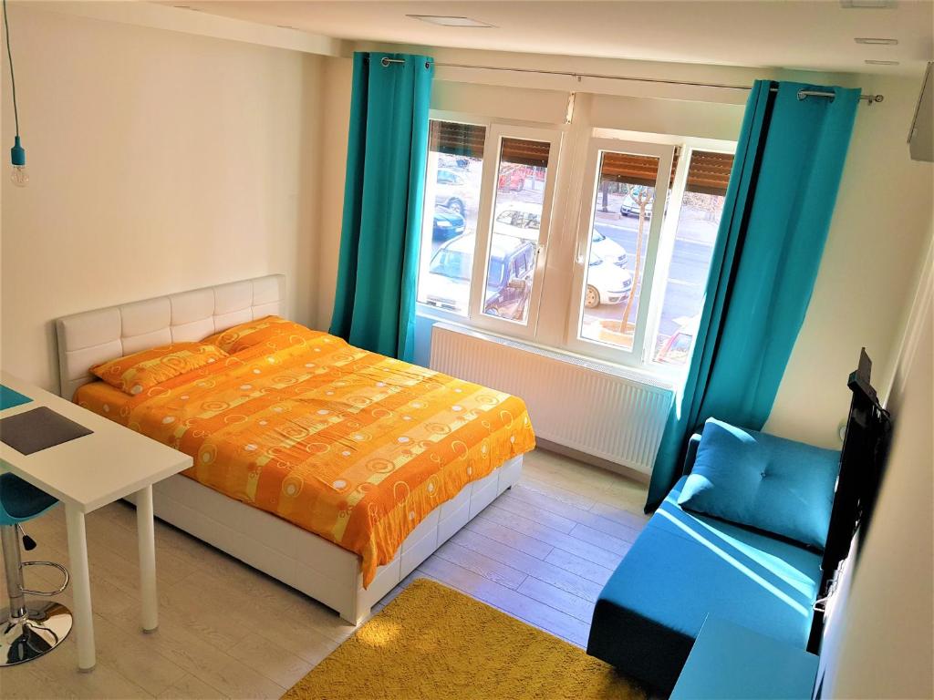 Schlafzimmer mit einem Bett, einem Schreibtisch und einem Fenster in der Unterkunft Asya Blue Studio in Belgrad
