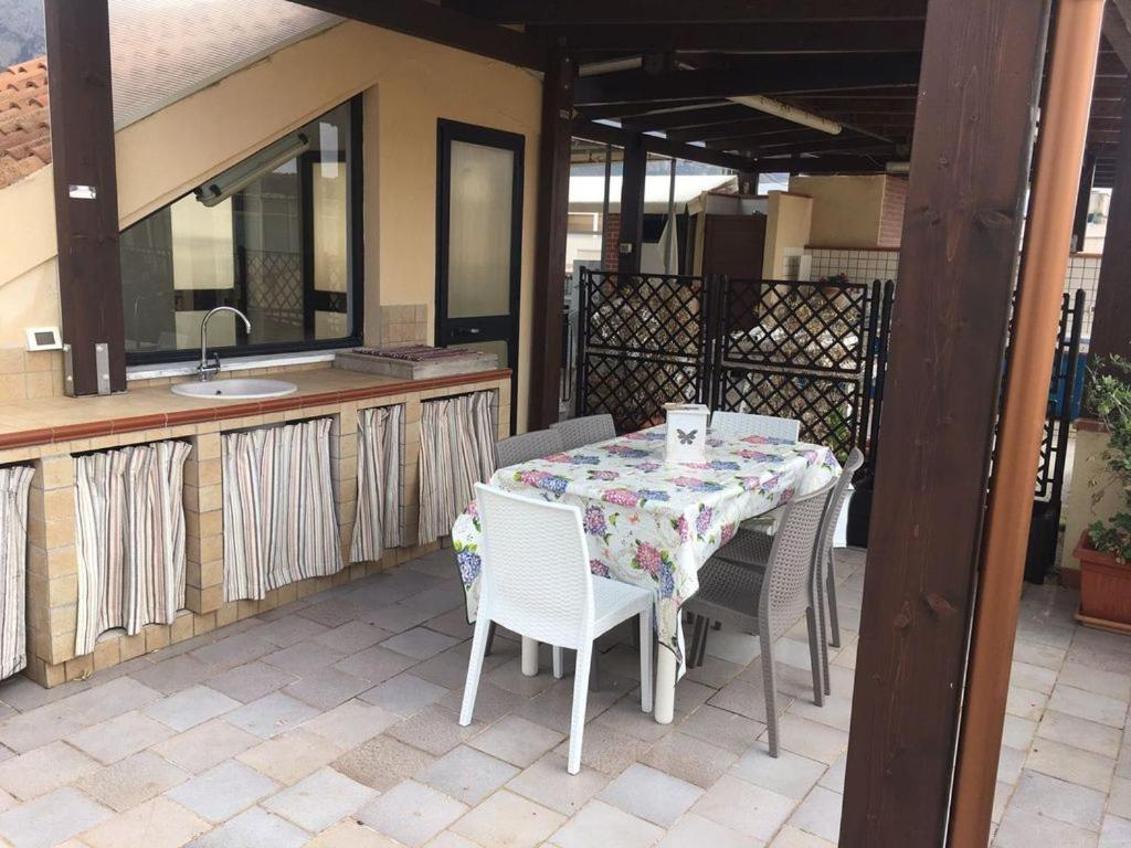 a table and chairs on a patio with a sink at ULISSE in San Vito lo Capo