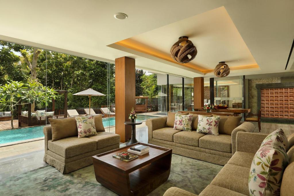 a living room with couches and a pool at Anantara Uluwatu Bali Resort in Uluwatu