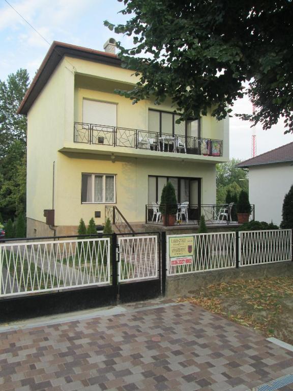 a house with a white fence in front of it at Rozs Ház in Zalakaros