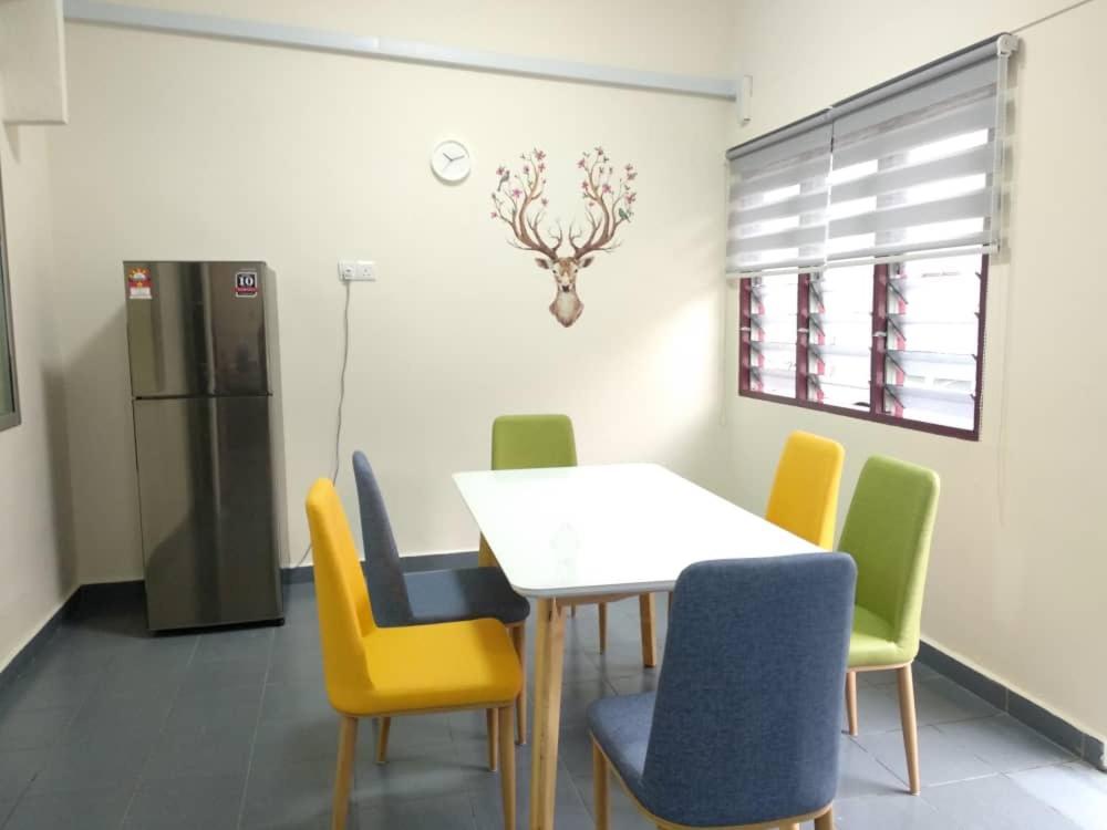 a dining room with a table and chairs and a refrigerator at D'Rusa Homestay in Port Dickson