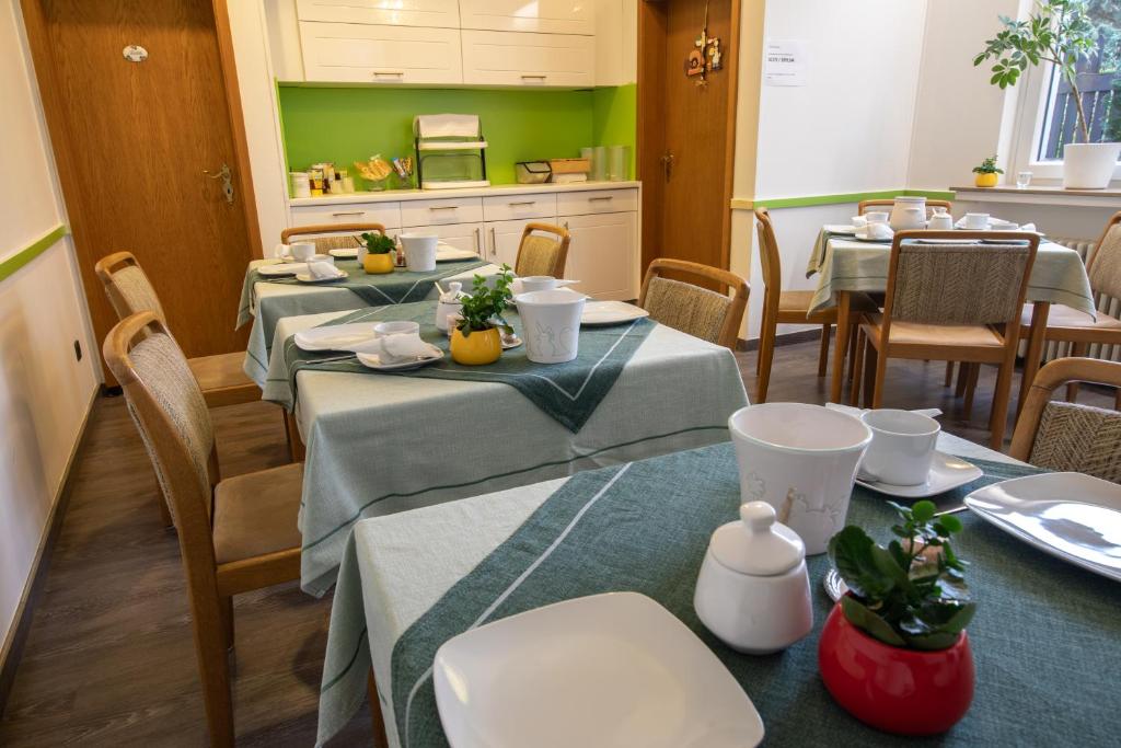 a dining room with four tables and green walls at Hotel Central in Menden