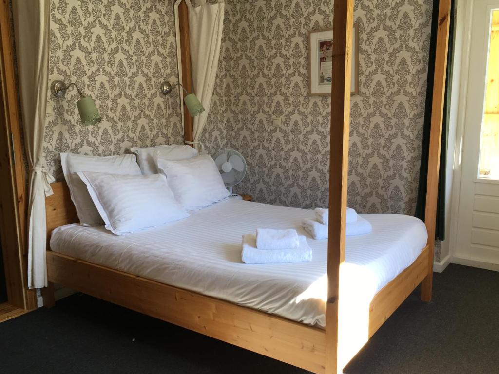a bedroom with a bed with white sheets and pillows at Hotel Dirbach Plage in Dirbach