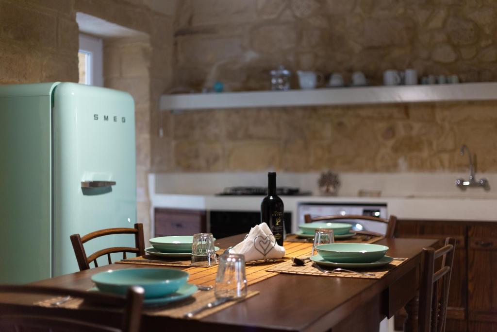 uma cozinha com uma mesa de madeira e uma garrafa de vinho em Casa Florean Centro Storico Lecce em Lecce