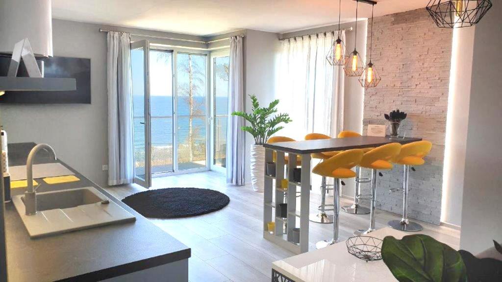a kitchen with a table and yellow chairs in a room at APARTAMENT ELEGANCE YELLOW in Rewal