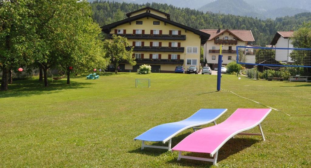 dos bancos de ping pong en un campo con un edificio en Pension Piovesan, en Faak am See