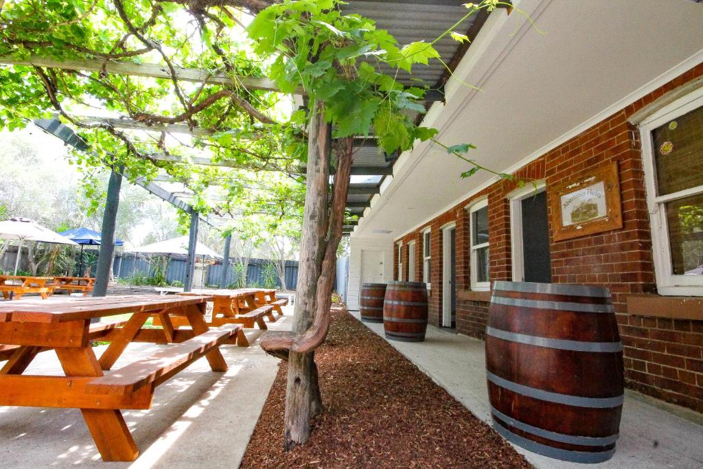 a row of wooden picnic tables next to a building at Abermain Hotel in Abermain