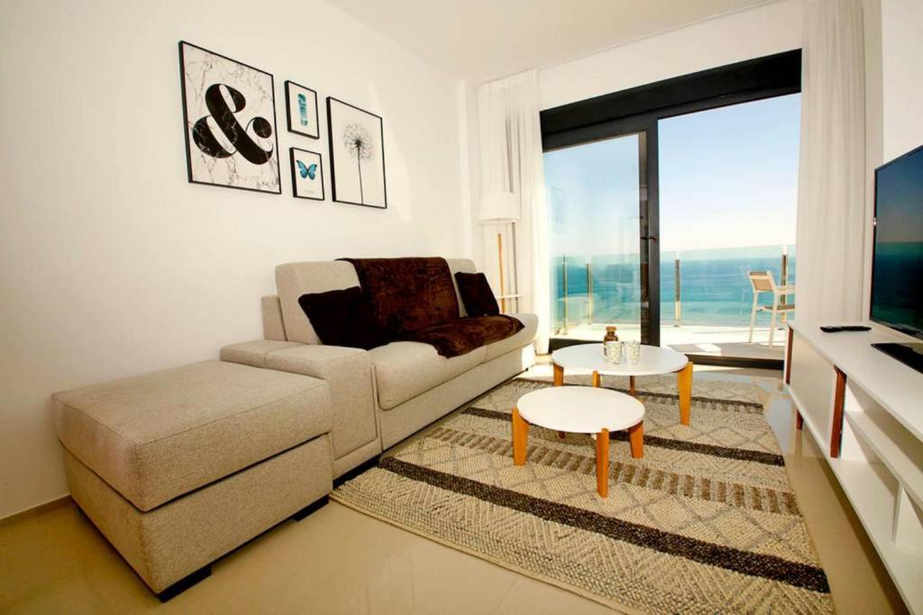 uma sala de estar com um sofá e uma mesa em Sea Coast Apartment em Arenales del Sol