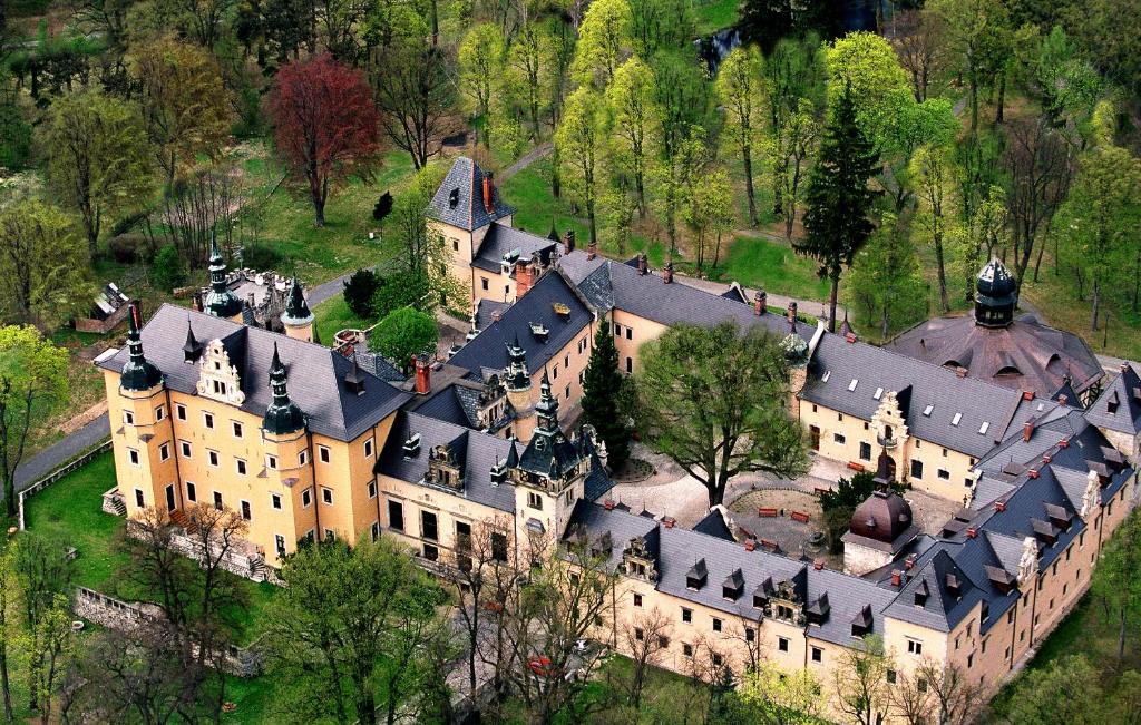 Aerial view of expansive castle complex, surrounded by trees.