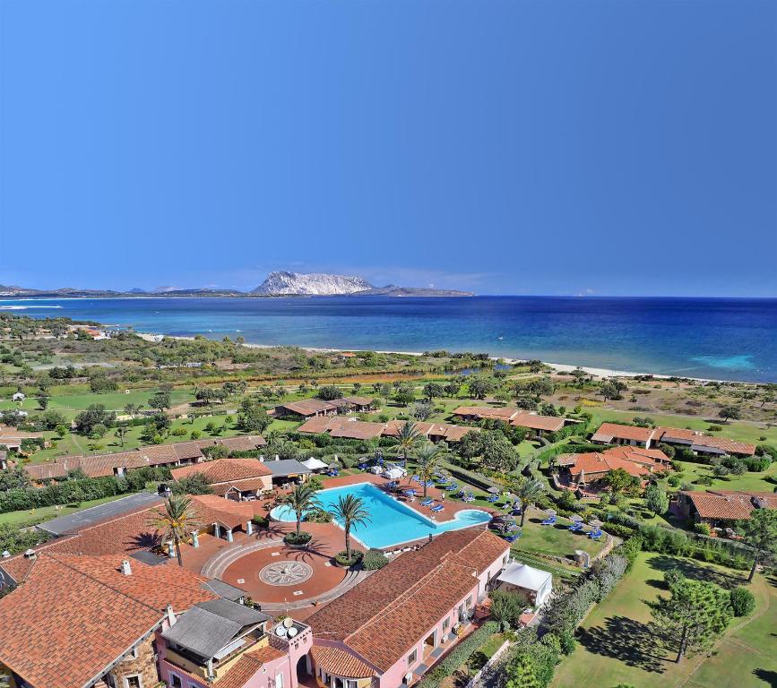 an aerial view of a resort with a pool and the ocean at TH San Teodoro - Liscia Eldi Village in San Teodoro