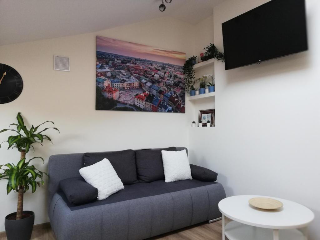 a living room with a blue couch and a tv at Voal Mini Apartament in Lublin