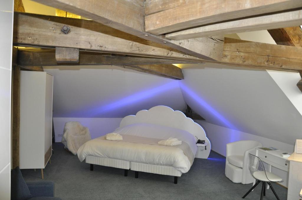 a bedroom with a white bed and a purple wall at Les Tonnelles in Bar-sur-Seine